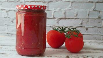 salsa de tomate en un frasco con tomate fresco en la mesa video