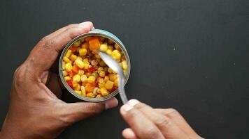 spoon pick sweet corn from a tin can video