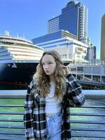 Education in Canada Universities and Colleges A girl stands in front of Canada Place Vancouver Downtown As well as travel and trips on a cruise ship, a huge ship stands in the background photo