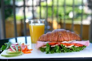 banner Croissant with prosciutto, poached egg, jamon blue, cheese, avocado, microgin and cherry tomatoes. Mediterranean appetizer. Breakfast concept. photo