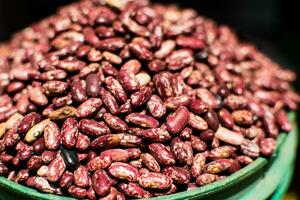 Bowl of red beans, piled up, in close-up and detail, with defocused background photo