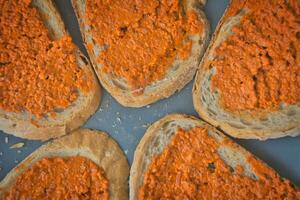 Directly above shot of slices of bread with vegan carrot spread. photo