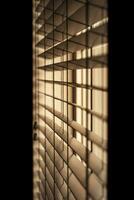 Vertical shot of venetian blinds creating a moody and noir inspired atmosphere. photo