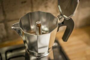 Brewing espresso coffee in a stovetop coffee maker photo