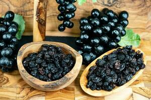 wine grapes raisins and wine berries on olive wood photo