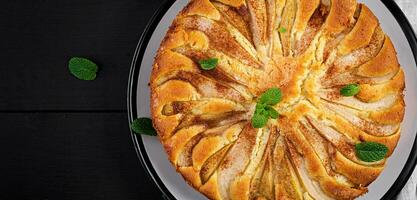 Homemade pie with pears and almond flour  on dark background. Top view, overhead photo