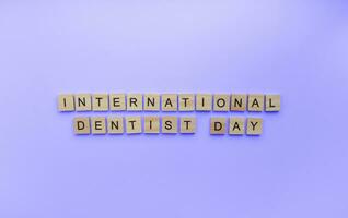 On March 6, International Dentist Day, a minimalistic banner with an inscription in wooden letters photo