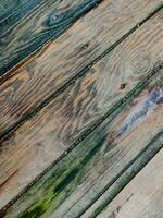 Background of wood coating made of boards with multicolored spots from humidity, diagonal lines, top view, close-up. photo