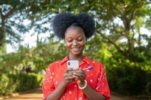 pretty black woman look very excited and rejoices while looking at her phone photo