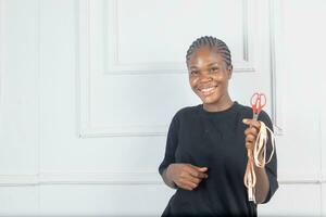 excited black female design professional with tape measure and scissors photo