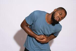 black man holding his stomach and feeling discomfort photo