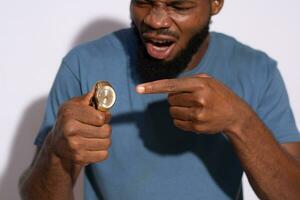 black man pointing to a watch with emotion on his face photo