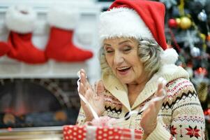 contento sonriente antiguo mujer con regalo en Navidad foto