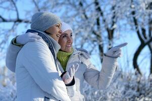 Happy women in winter clothes posing outdoors photo