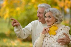 happy senior couple standing in autumn park photo