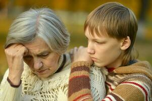 Sad Grandmother with boy in the park photo