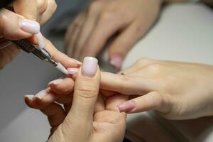 Female hands and tools for manicure, process of performing manicure photo