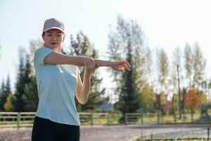 A young beautiful woman in sportswear plays sports at a local stadium photo