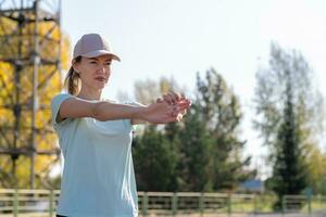 A young beautiful woman in sportswear plays sports at a local stadium photo