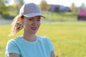 A young beautiful woman in sportswear plays sports at a local stadium photo