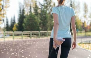 A young beautiful woman in sportswear plays sports at a local stadium photo