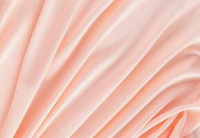Elegant textile background in peach color with soft pleats. Festive background of the color of the year 2024 peach fuzz. A copy space. photo