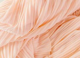 Luxurious chiffon factory fabric. Air waves of peach-colored folds. Layout for design. Color of the Year 2024 Peach Fuzz. photo