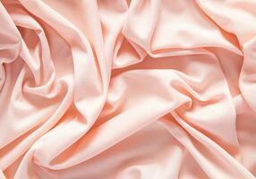 Elegant satin fabric with a peachy color. luxurious texture of the soft folds . festive background. design. color of the year peachy fuzz. photo