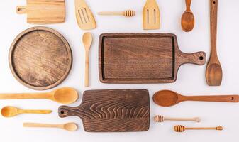 A set of various wooden spoons, spatulas, cutting board made of eco-friendly materials on a light countertop. kitchen background. Top view. Flat lay photo