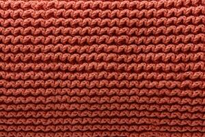AI generated orange knitted wool fabric texture background, soft and cozy patterned surface photo