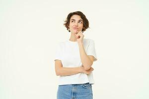 Image of girl thinking, making thoughtful face, making decision, choosing, standing over white studio background photo
