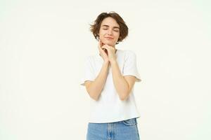 Portrait of carefree girl, gentle and feminine woman with short hair, laughing, posing over white studio background photo