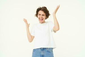 Portrait of woman celebrating, winning prize, triumphing, standing over white studio background photo