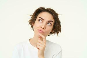 Close up portrait of woman with thoughtful face, thinking of solution, pondering, making choice, standing over white studio background photo