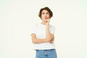Image of girl thinking, making thoughtful face, making decision, choosing, standing over white studio background photo