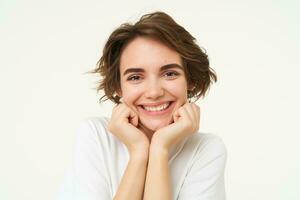 Close up of excited young brunette woman, looking with anticipation at camera, dreaming, wishing for something, isolated over white background photo