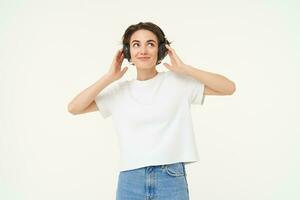 Portrait of smiling young woman, listening to music, enjoying dancing to favourite song, isolated on white background photo