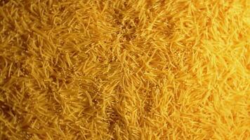 Background of Uncooked Golden Noodles that Rotating Clockwise Top View. Texture of Dry Vermicelli Turning Around. Raw Pasta with Low Key Light Right Rotation video