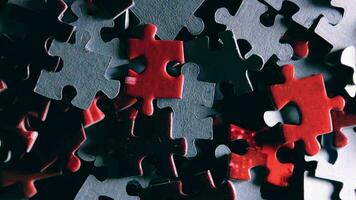 Background of Colored Puzzle Pieces that Slowly Rotating Clockwise Top View, CloseUp. Texture of Incomplete Red and Grey Jigsaw Puzzle with Low Key Light Right Rotation video