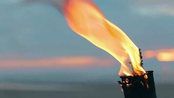 tropical bambú antorcha ardiente en el playa a verano noche. decorativo vela tiene un masivo naranja fuego utilizando petróleo combustible o queroseno lento movimiento. de cerca estático Disparo video