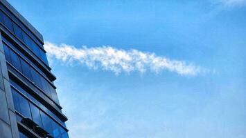 a cloud is seen in the blue sky above a building photo