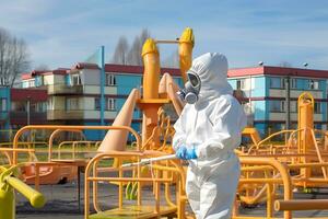 AI generated A man in a white protective suit and mask treats a children's playground with a disinfectant to avoid an outbreak of mycoplasma pneumonia or Covid-19 among children photo