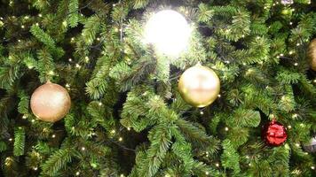 Close up video of a Christmas tree decorated with balls and twinkling lights