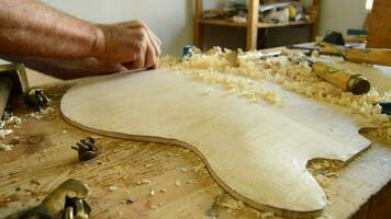 Luthier working on the top of a bowed instrument video