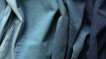 close-up panorâmico de tecido jeans amassado mostrando diferentes tons de azul claro a azul escuro video