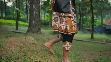 a Sundanese man walking alone in the forest with makeup on his face video