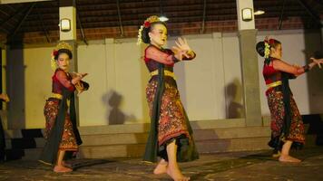 an Asian woman dances on stage while looking at an audience with a piercing gaze to capture the attention video