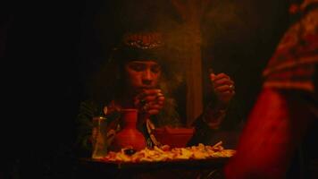 a shaman is performing a ritual with spells and offerings on a table video