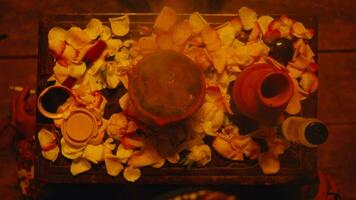 a jug and roses strewn on the table during a scary ritual video