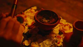 a woman is taking lipstick from a ritual table in a scary hut video